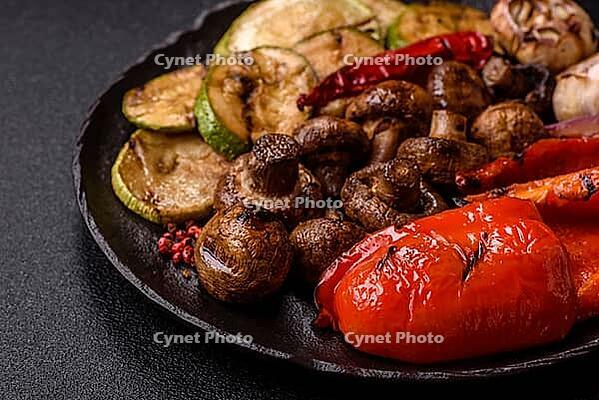 Grilled vegetables, bell peppers, mushrooms, and zucchini, a vegetarian healthy meal with sauce. Grilled vegetables on a plate as a food background for your design [IBR124865238]