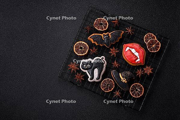Halloween cookies, sweets, or gingerbread, a cat, a bat, and a hat. Halloween cookies as a backdrop for your design [IBR124865240]