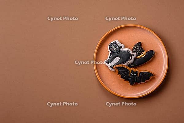 Halloween cookies, sweets, or gingerbread, a cat, a bat, and a hat. Halloween cookies as a backdrop for your design [IBR124865247]