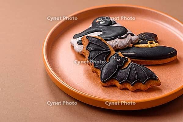 Halloween cookies, sweets, or gingerbread, a cat, a bat, and a hat. Halloween cookies as a backdrop for your design [IBR124865248]