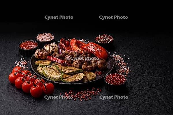 Grilled vegetables, bell peppers, mushrooms, and zucchini, a vegetarian healthy meal with sauce. Grilled vegetables on a plate as a food background for your design [IBR124865250]