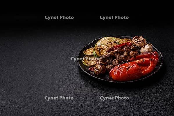 Grilled vegetables, bell peppers, mushrooms, and zucchini, a vegetarian healthy meal with sauce. Grilled vegetables on a plate as a food background for your design [IBR124865252]
