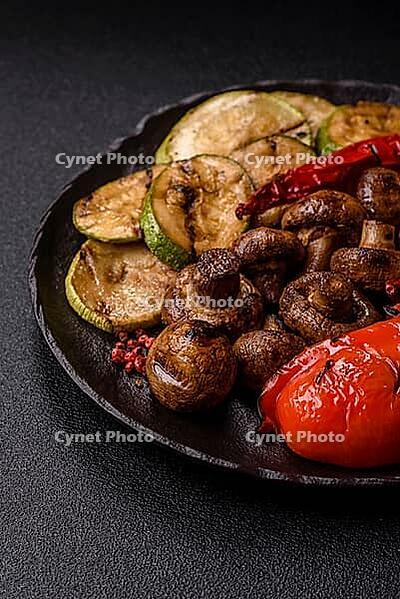 Grilled vegetables, bell peppers, mushrooms, and zucchini, a vegetarian healthy meal with sauce. Grilled vegetables on a plate as a food background for your design [IBR124865254]