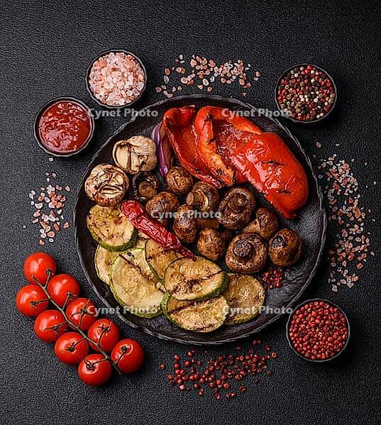 Grilled vegetables, bell peppers, mushrooms, and zucchini, a vegetarian healthy meal with sauce. Grilled vegetables on a plate as a food background for your design [IBR124865255]