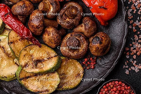 Grilled vegetables, bell peppers, mushrooms, and zucchini, a vegetarian healthy meal with sauce. Grilled vegetables on a plate as a food background for your design [IBR124865256]