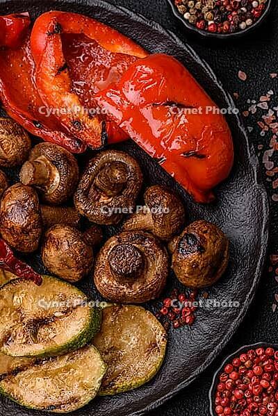 Grilled vegetables, bell peppers, mushrooms, and zucchini, a vegetarian healthy meal with sauce. Grilled vegetables on a plate as a food background for your design [IBR124865260]