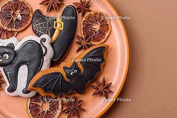 Halloween cookies, sweets, or gingerbread, a cat, a bat, and a hat. Halloween cookies as a backdrop for your design [IBR124865265]