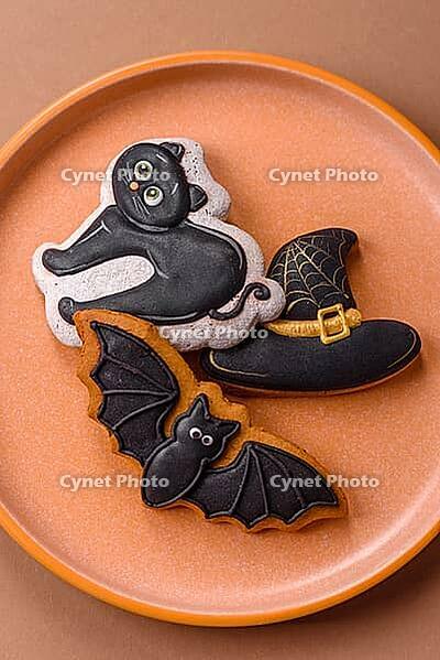 Halloween cookies, sweets, or gingerbread, a cat, a bat, and a hat. Halloween cookies as a backdrop for your design [IBR124865268]