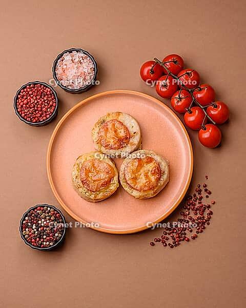Round fish or chicken cutlets baked with tomato and cheese. Fish cutlets as a food backdrop for your design [IBR124865272]