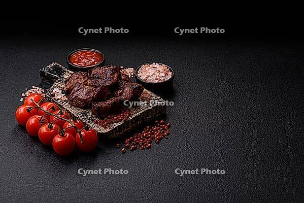 Beef, grilled meat in pieces, or kebab with sauce and vegetables. Beef in pieces as a food background for your design [IBR124865275]