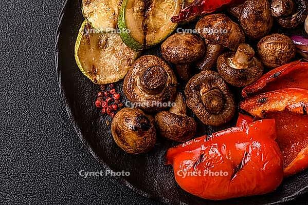 Grilled vegetables, bell peppers, mushrooms, and zucchini, a vegetarian healthy meal with sauce. Grilled vegetables on a plate as a food background for your design [IBR124865282]