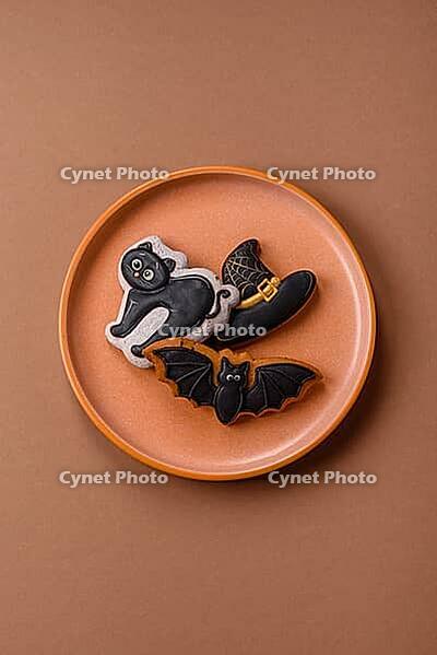 Halloween cookies, sweets, or gingerbread, a cat, a bat, and a hat. Halloween cookies as a backdrop for your design [IBR124865285]
