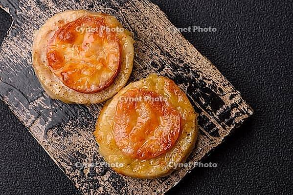 Round fish or chicken cutlets baked with tomato and cheese. Fish cutlets as a food backdrop for your design [IBR124865293]