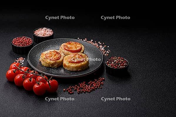 Round fish or chicken cutlets baked with tomato and cheese. Fish cutlets as a food backdrop for your design [IBR124865296]
