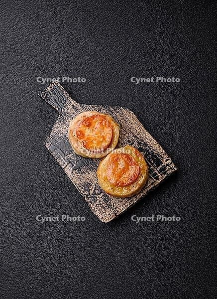Round fish or chicken cutlets baked with tomato and cheese. Fish cutlets as a food backdrop for your design [IBR124865297]