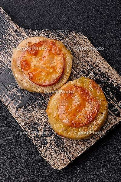 Round fish or chicken cutlets baked with tomato and cheese. Fish cutlets as a food backdrop for your design [IBR124865298]