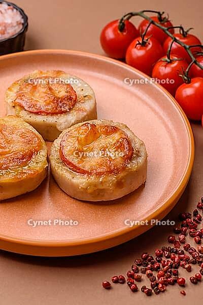 Round fish or chicken cutlets baked with tomato and cheese. Fish cutlets as a food backdrop for your design [IBR124865300]