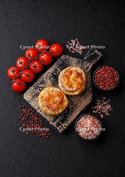 Round fish or chicken cutlets baked with tomato and cheese. Fish cutlets as a food backdrop for your design [IBR124865301]
