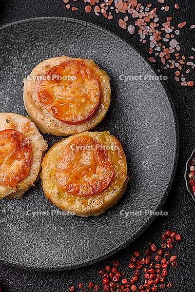 Round fish or chicken cutlets baked with tomato and cheese. Fish cutlets as a food backdrop for your design [IBR124865305]