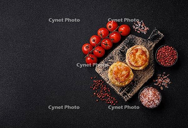 Round fish or chicken cutlets baked with tomato and cheese. Fish cutlets as a food backdrop for your design [IBR124865310]