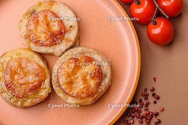 Round fish or chicken cutlets baked with tomato and cheese. Fish cutlets as a food backdrop for your design [IBR124865311]