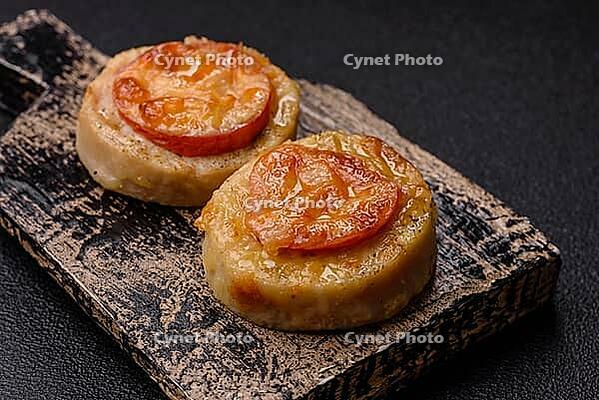 Round fish or chicken cutlets baked with tomato and cheese. Fish cutlets as a food backdrop for your design [IBR124865313]