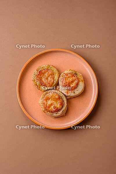 Round fish or chicken cutlets baked with tomato and cheese. Fish cutlets as a food backdrop for your design [IBR124865318]