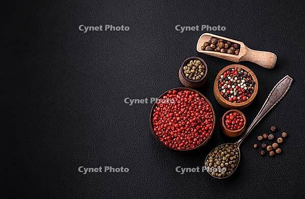 Food, Composition, concept, consisting of several types of different colors of allspice in bowls and spoons on a dark concrete background [IBR124876414]