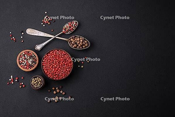Food, Composition, concept, consisting of several types of different colors of allspice in bowls and spoons on a dark concrete background [IBR124876415]