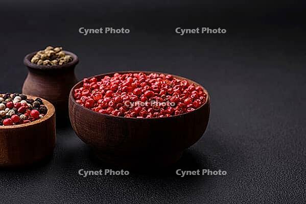 Food, Composition, concept, consisting of several types of different colors of allspice in bowls and spoons on a dark concrete background [IBR124876417]