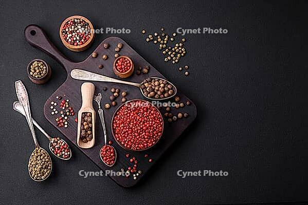 Food, Composition, concept, consisting of several types of different colors of allspice in bowls and spoons on a dark concrete background [IBR124876423]
