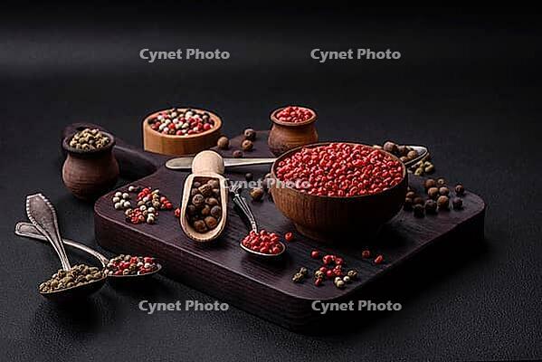 Food, Composition, concept, consisting of several types of different colors of allspice in bowls and spoons on a dark concrete background [IBR124876424]