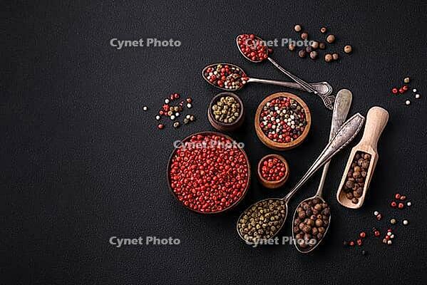Food, Composition, concept, consisting of several types of different colors of allspice in bowls and spoons on a dark concrete background [IBR124876425]