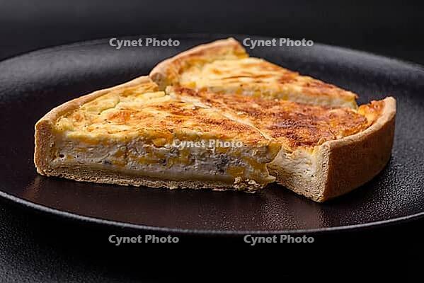 Food, Beautiful delicious quiche pie with four types of cheese with spices and herbs on a dark concrete background [IBR124876428]
