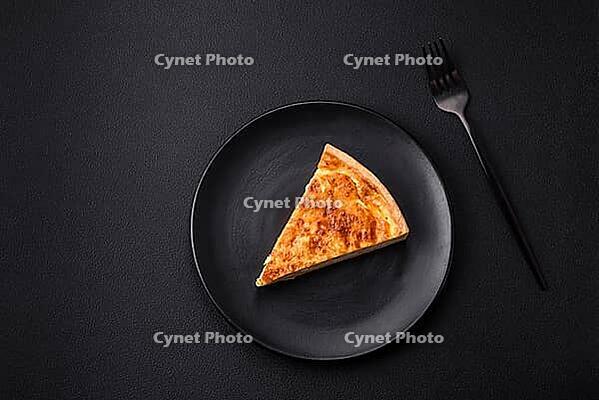 Food, Beautiful delicious quiche pie with four types of cheese with spices and herbs on a dark concrete background [IBR124876432]