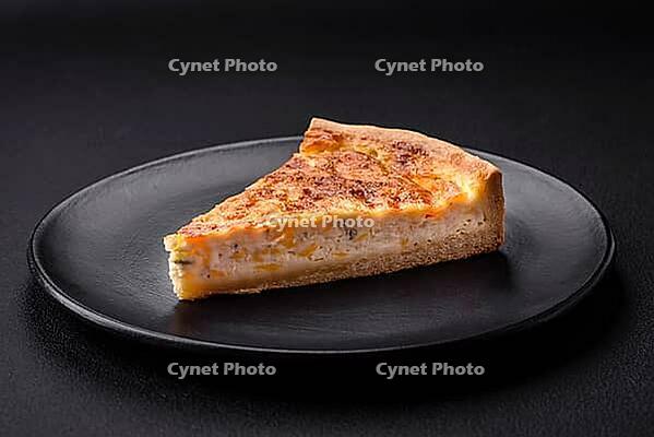 Food, Beautiful delicious quiche pie with four types of cheese with spices and herbs on a dark concrete background [IBR124876433]