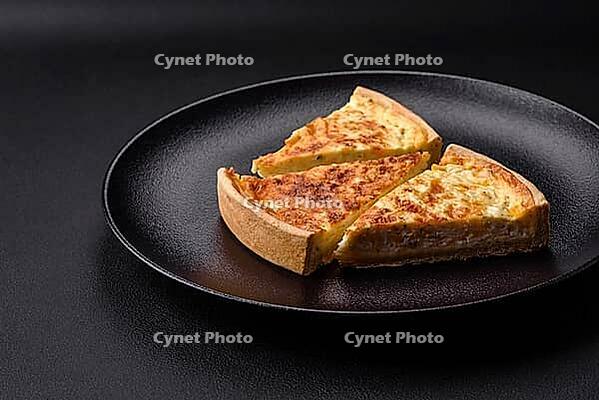 Food, Beautiful delicious quiche pie with four types of cheese with spices and herbs on a dark concrete background [IBR124876434]