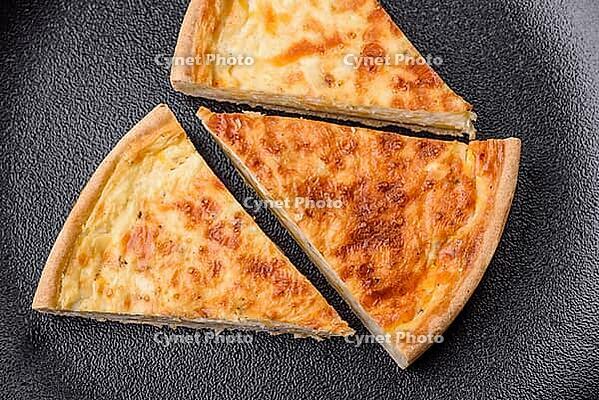 Food, Beautiful delicious quiche pie with four types of cheese with spices and herbs on a dark concrete background [IBR124876436]