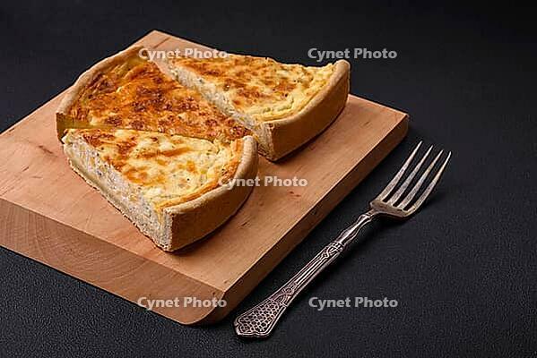 Food, Beautiful delicious quiche pie with four types of cheese with spices and herbs on a dark concrete background [IBR124876440]