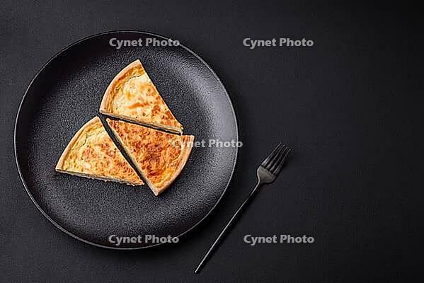 Food, Beautiful delicious quiche pie with four types of cheese with spices and herbs on a dark concrete background [IBR124876444]