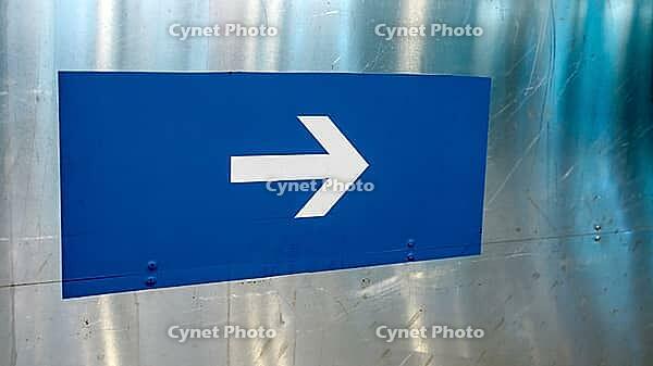 Blue sign with white arrow on a metal surface, pointing right, Munich, Germany [IBR124899024]