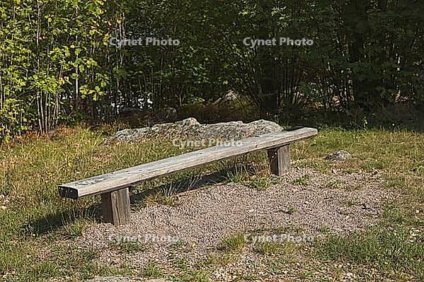 Old weathered wood bench designed for outdoor seating in park on sunny summer day, Loviisa, Finland [IBR124899519]