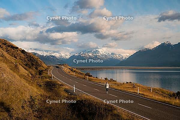 Aerial view of person walking on road on Lake Pukaki with Mount Cook in the background, New Zealand [IBR124899547]