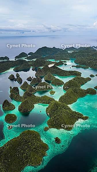 Aerial view of many small tropical islands with turquoise water and exposed reefs, Pulau Wayag, Raja Ampat, West Papua, Indonesia [IBR124899554]