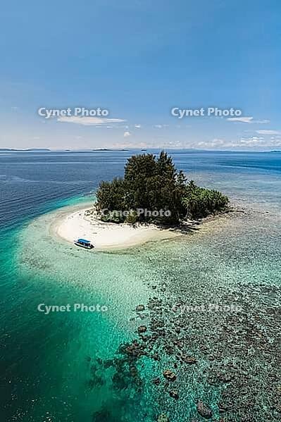 Aerial view of a small tropical island with turquoise water, white sandy beach, a boat and a proposed reef, Raja Ampat, West Papua, Indonesia [IBR124899555]