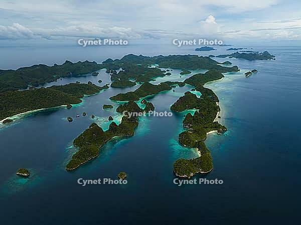 Aerial view of many small tropical islands with turquoise water and exposed reefs, Pulau Wayag, Raja Ampat, West Papua, Indonesia [IBR124899563]