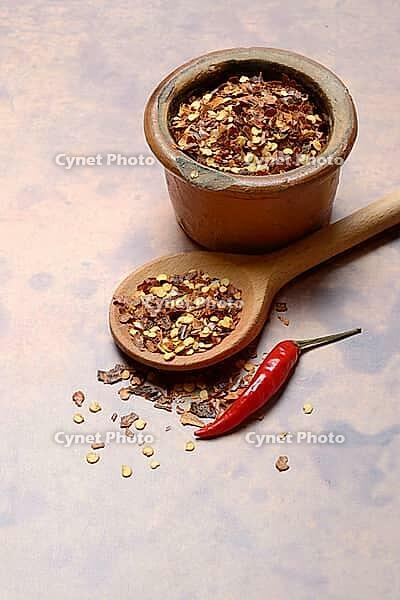 Chilli, chilli flakes in cooking spoon and pot, Capsicum annuum [IBR124899845]