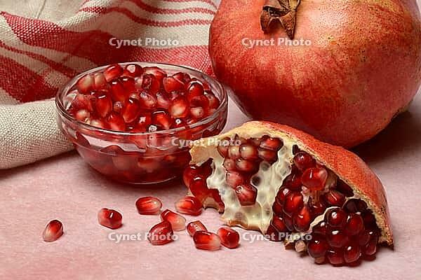 Opened pomegranate and pomegranate seeds in skin, Punica granatum [IBR124899860]