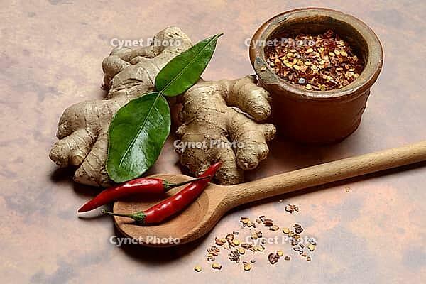 Ginger, ginger root with kaffir lime leaf and chili pepper and chilli flakes in pot [IBR124899863]