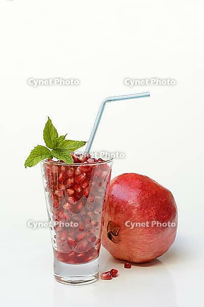 Pomegranate seeds in glass and pomegranate, Punica granatum [IBR124899873]